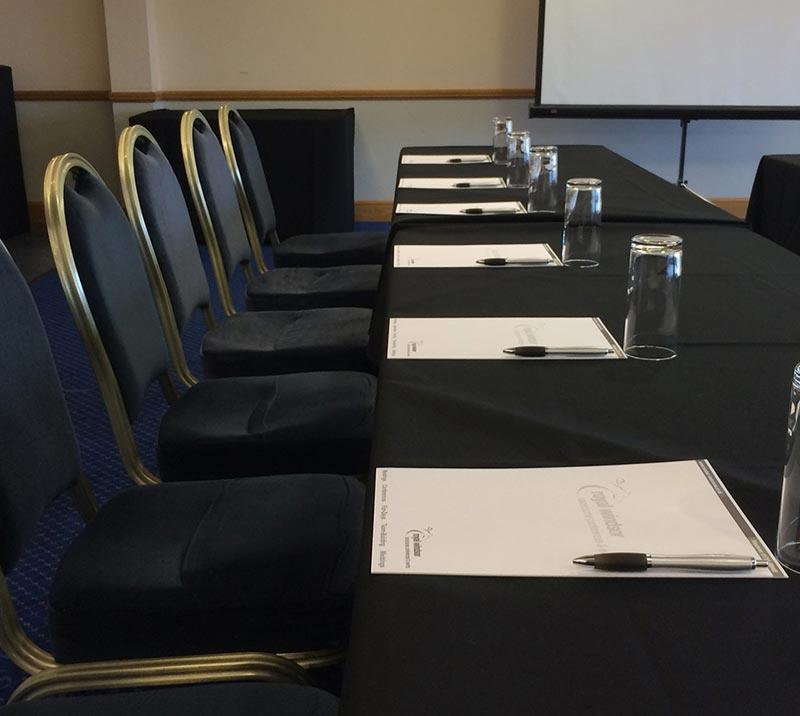 A smart looking table and chairs decorated with black tablecloth.