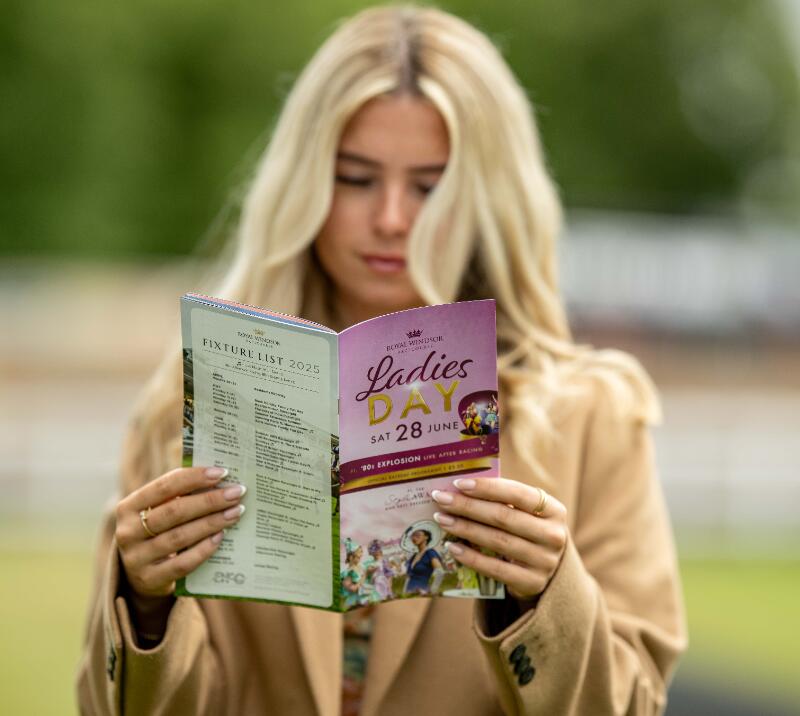 A close up of a Windsor Racecourse visitor reading the horse race card