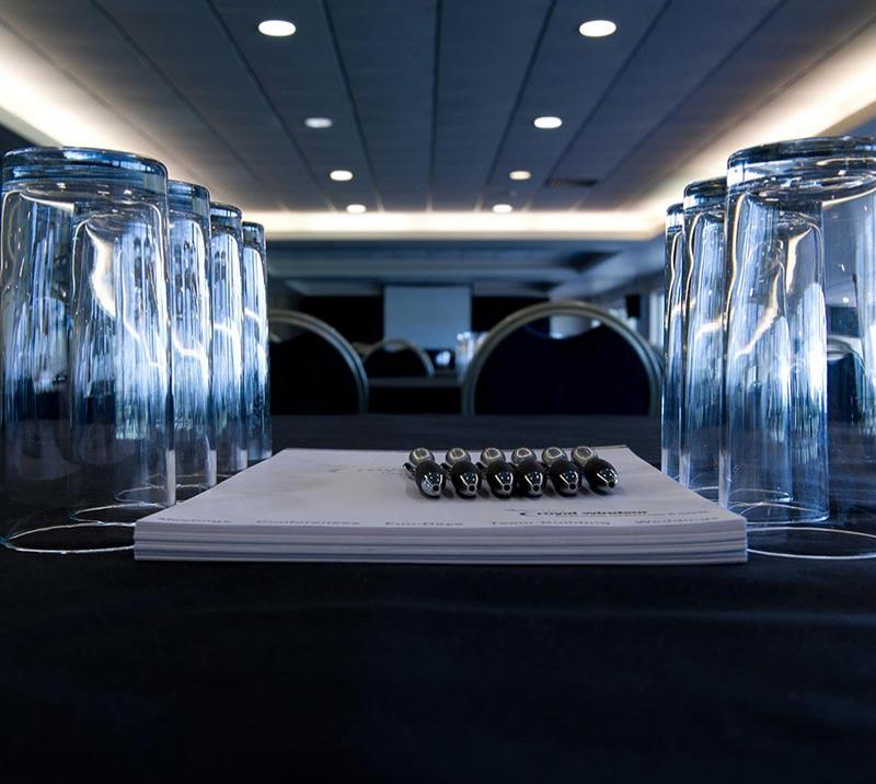 Drinking glasses, notepaper and pencils sat on a desk.