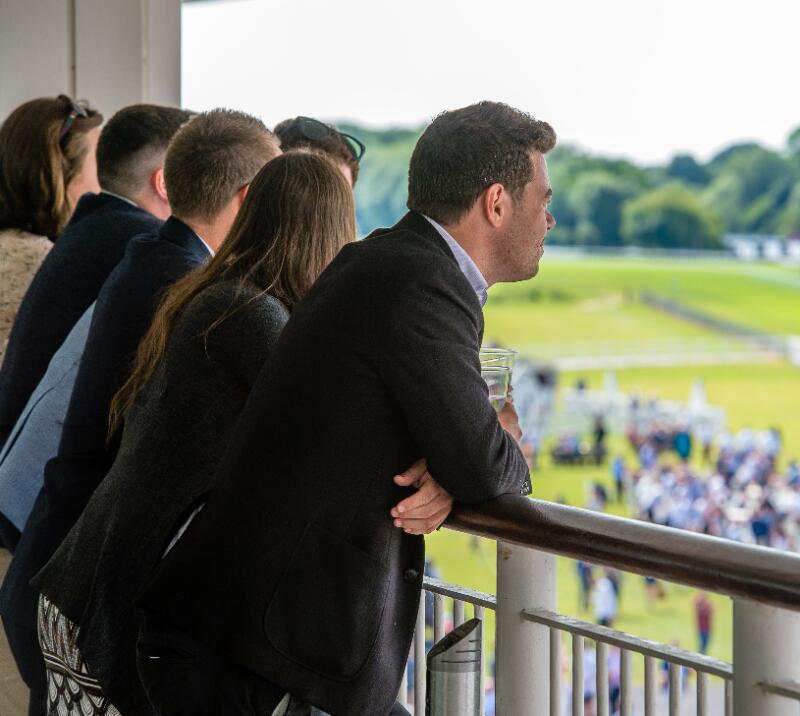 A group of hospitality guests looking out from their balcony