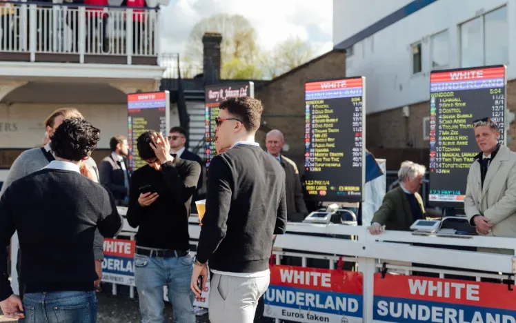 A group of race goers in front of bookmakers at Windsor Races