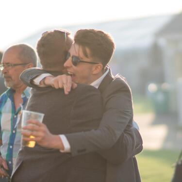 Two race goers hug and celebrate a win at Windsor Racecourse