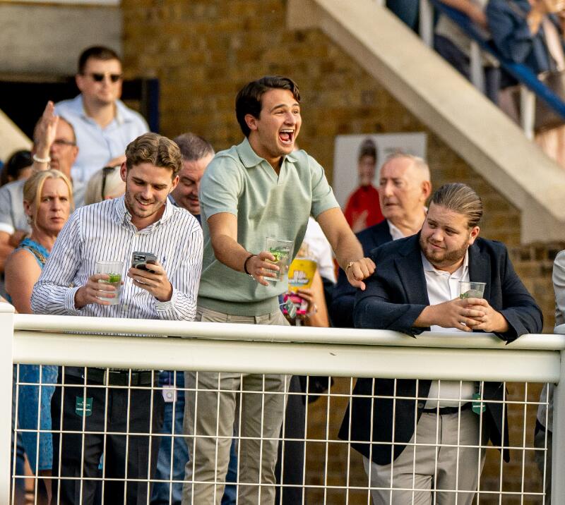 A race goer cheers enthusiastically for a win at Windsor Racecourse
