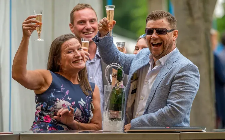 Race goers at Windsor toasting champagne to the camera