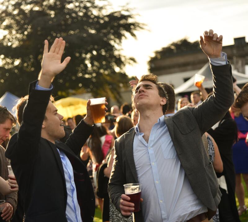 Two smartly dressed guys enjoying music at Gents Day at Windsor Racecourse