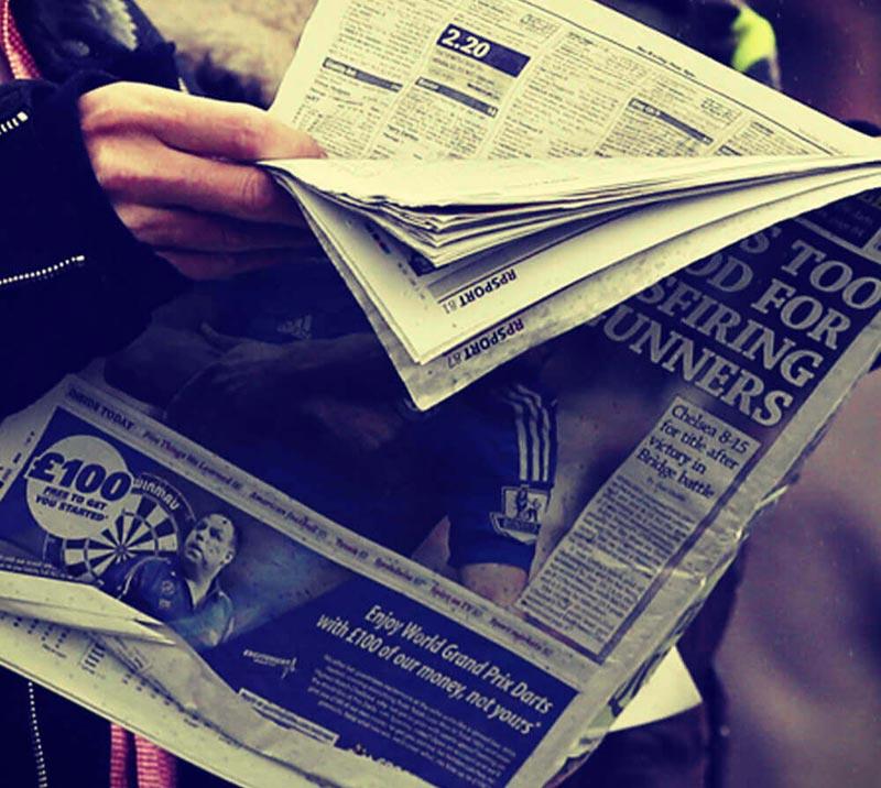 A race goer reading the racing post at Royal Windsor Racecourse