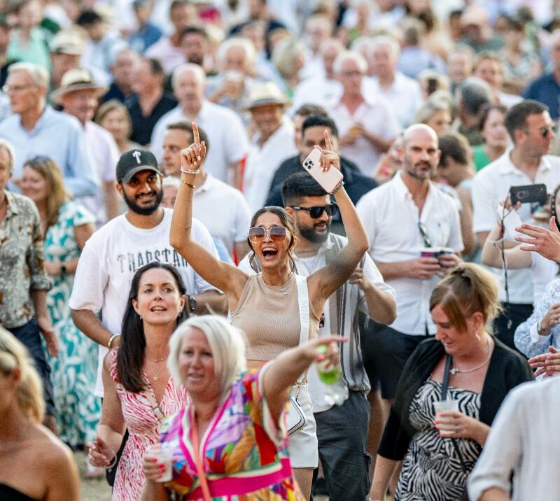 A race goer sings and dances in the crowd at Windsor Racecourse
