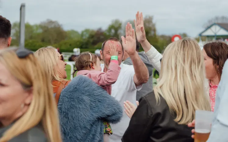 A family hi-fives each other at Windsor races